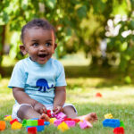 Portrait of a little african american baby boy playing outdoor in the grass